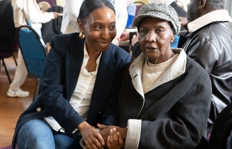 Michaela holds the hand of Vanda, her nan